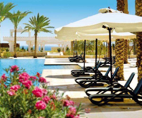 Zwembad met ligbedden van Reef Oasis Blue Bay Resort en Spa